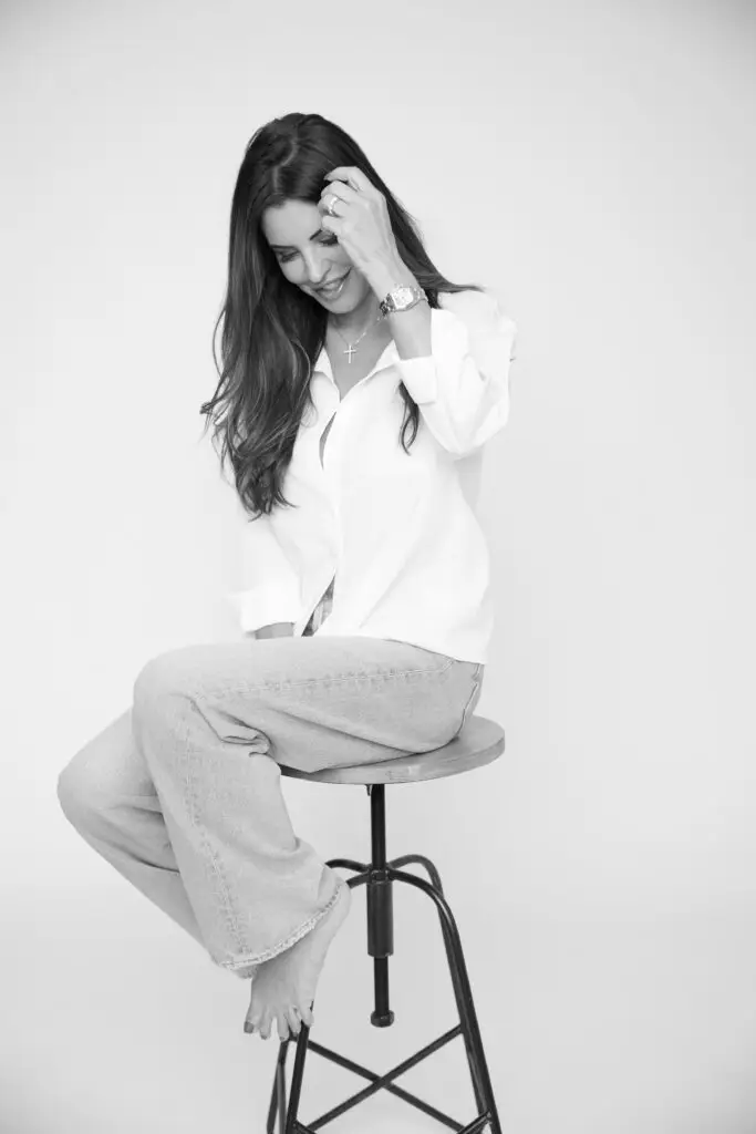 beautiful woman in studio being photographed wearing white men's shirt laughing